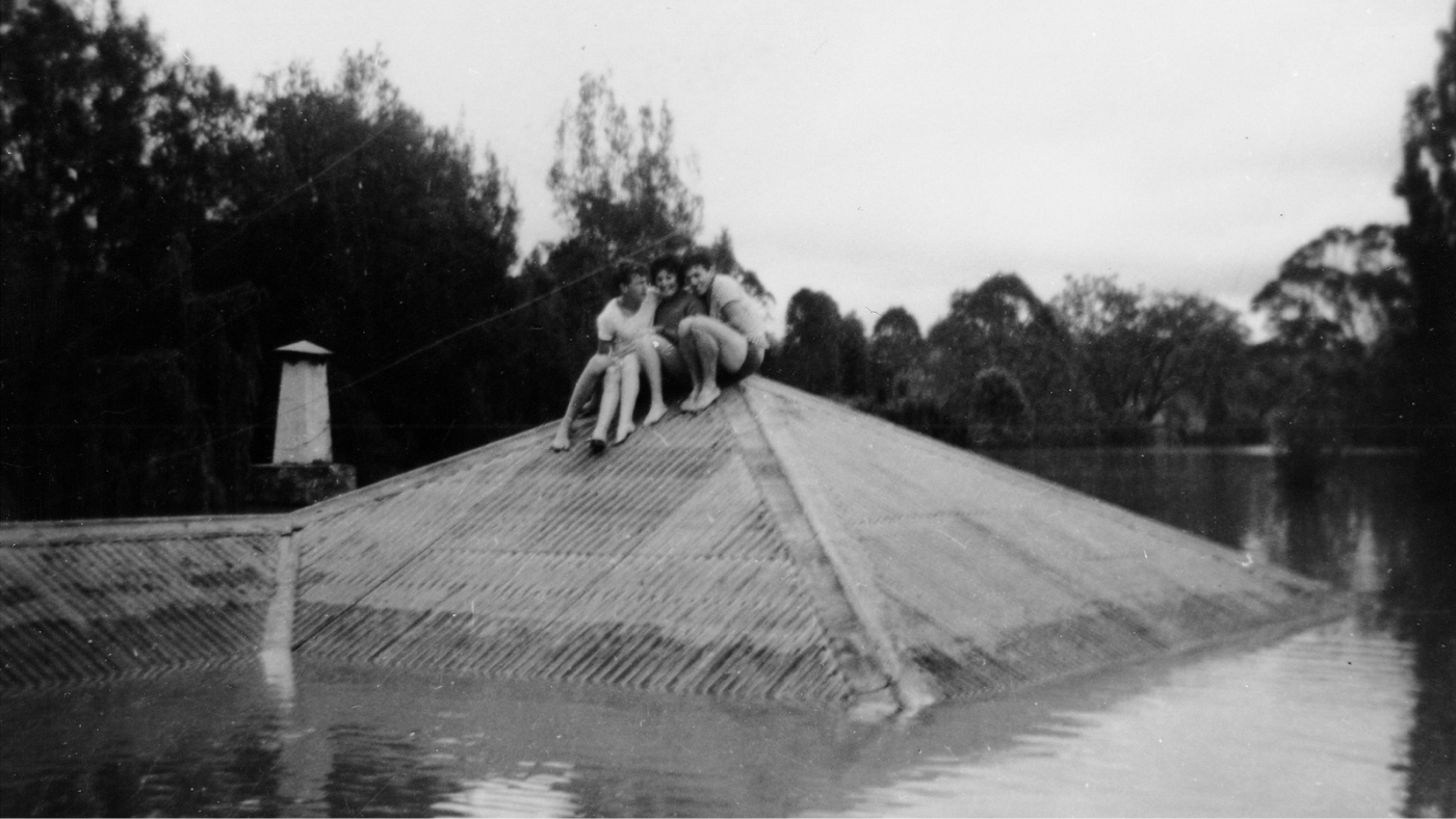 Black and white photo, residents sitting on a roof in Windsor, NSW 1961 - Barry Gibbs Collection Hawkesbury City 