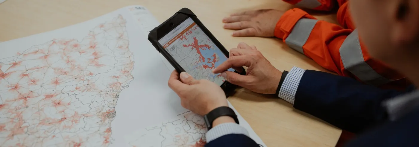 Person scrolling through an NSW SES zones map on a tablet.