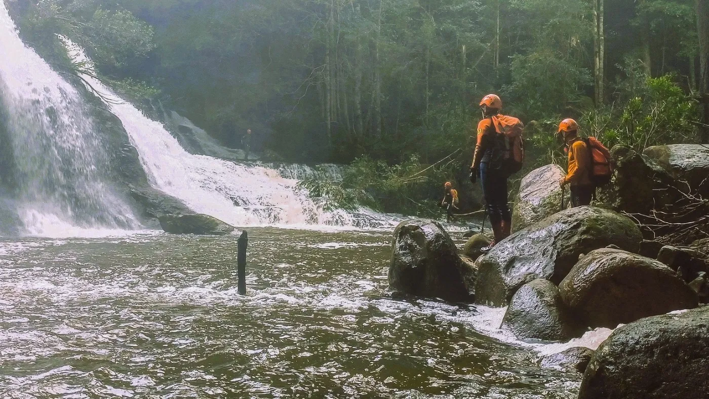 Bush serach and rescure volunteers standing by a waterfall