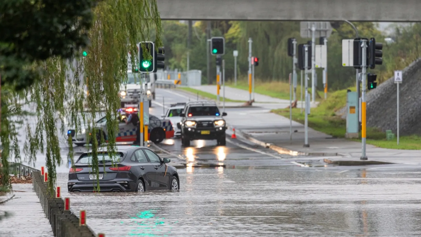 Cars driving through a flooded road.