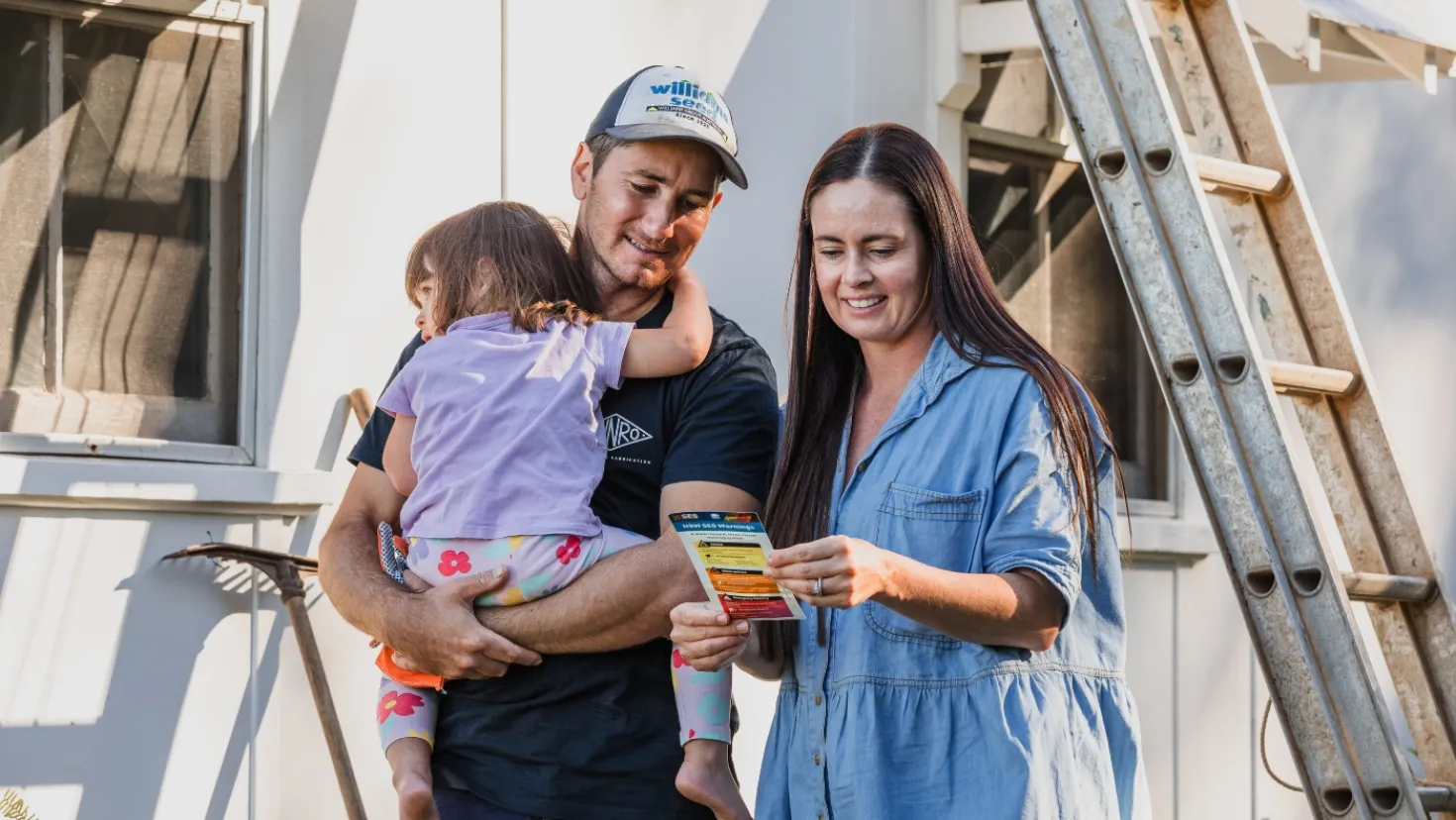  A couple and their daughter reading a guide about the importance of creating an emergency plan.