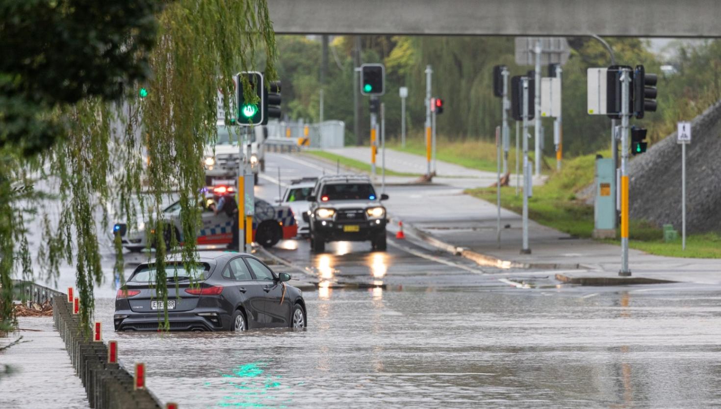 Cars driving through a flooded road.