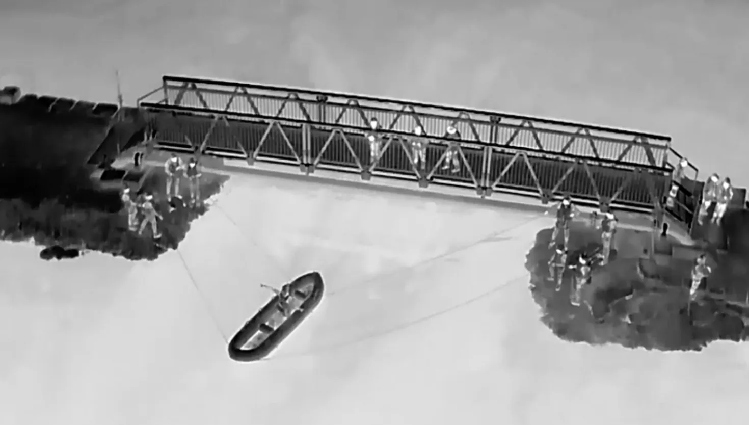 Drone shot of a boat on water next to a bridge