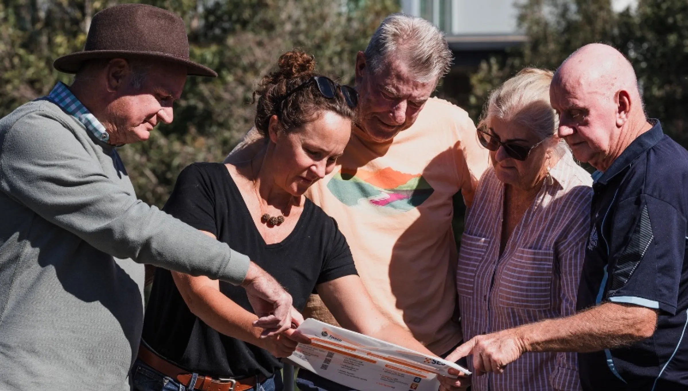 Five community members looking at a flood plan together.