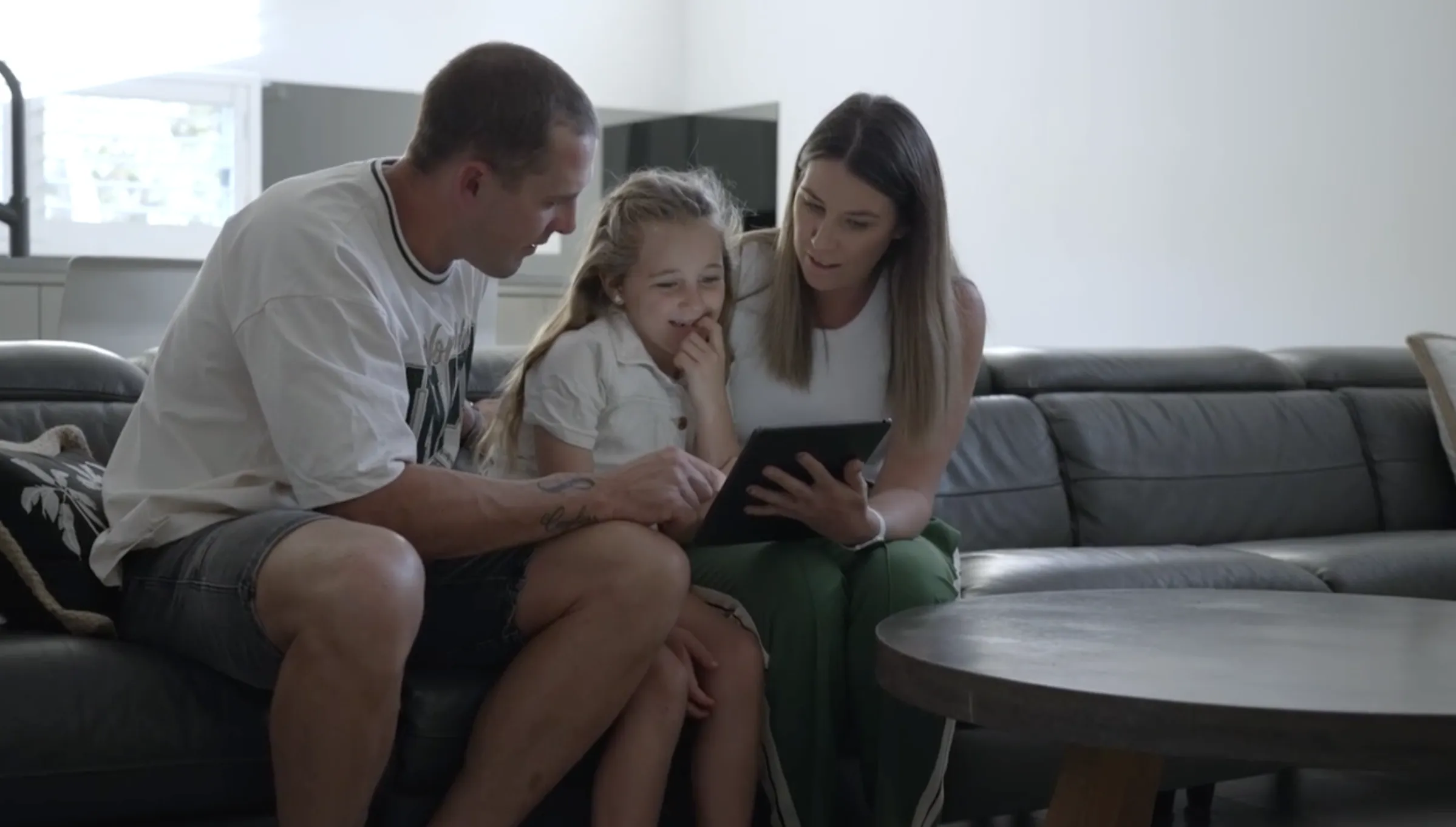 A family is gathered on the couch going through their emergency plan on a tablet